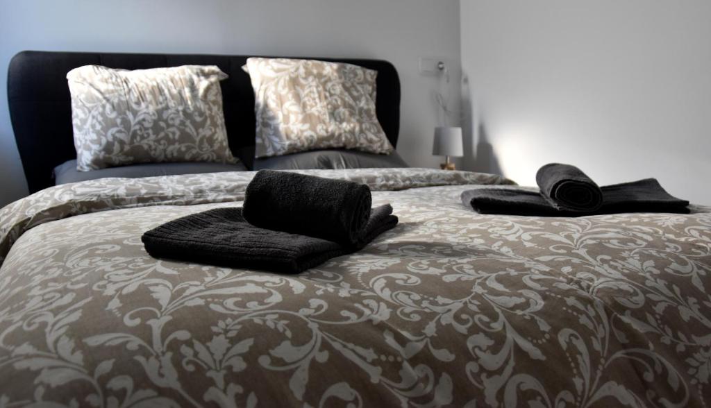 ein Bett mit schwarzen Handtüchern und Kissen darauf in der Unterkunft A Muralha in Porto