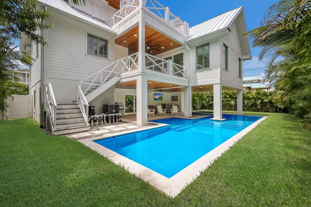 uma casa com piscina em frente a uma casa em Sweet and Salty em Holmes Beach