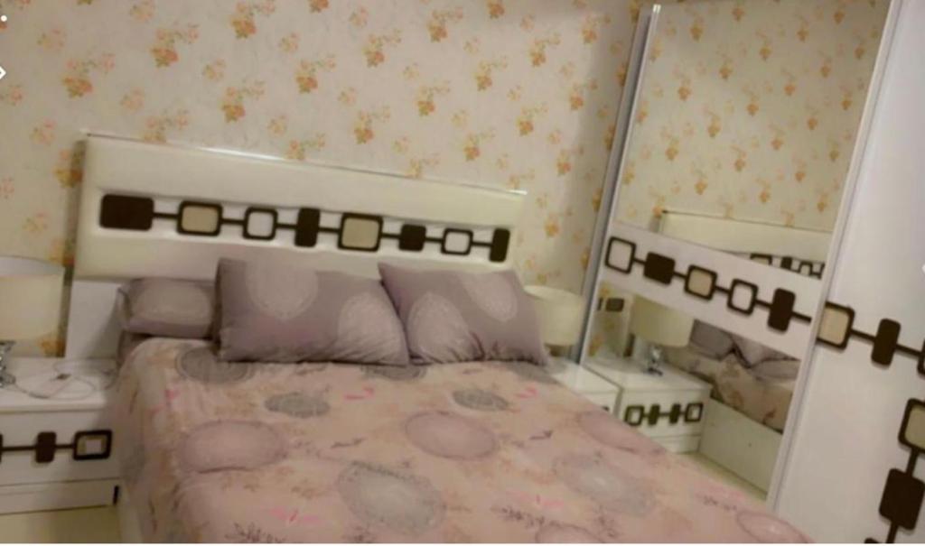 ein Schlafzimmer mit einem Bett und zwei Spiegeln in der Unterkunft Hotel apartment in Kairo