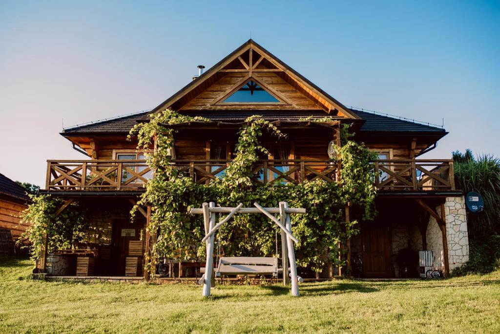 a wooden house with a cross in front of it at Dom Lawendowy w Winnicy Nad Źródłem in Sierzawy