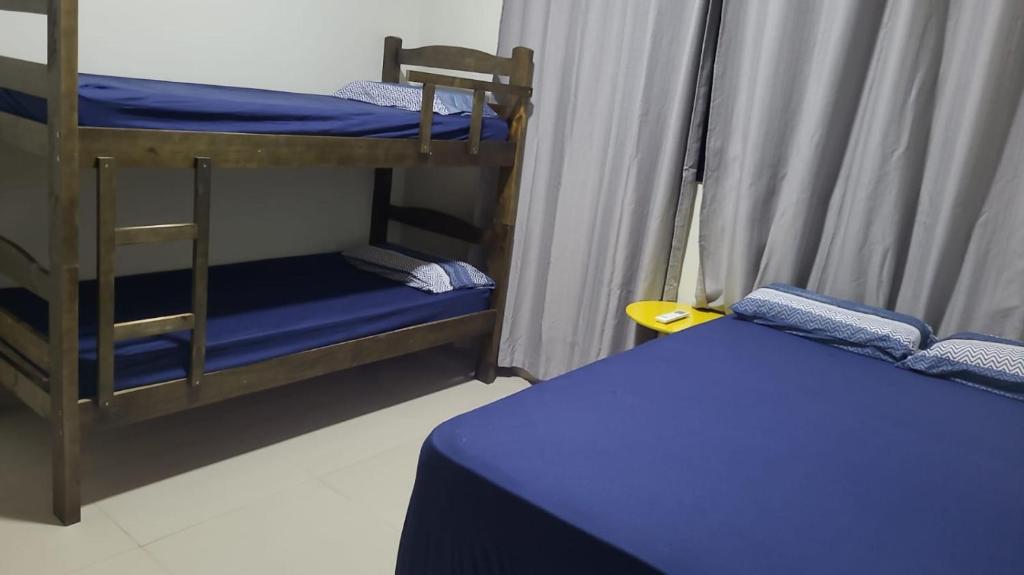 um quarto com 2 beliches e uma cama azul em Recanto da Tairine em Olímpia