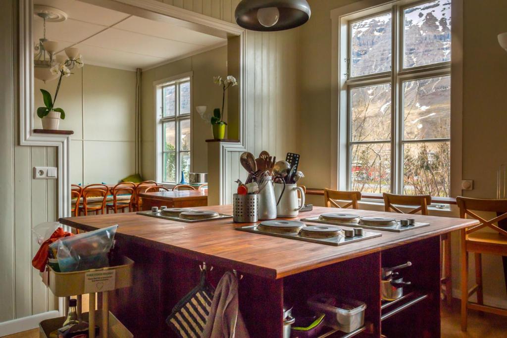 a kitchen with a wooden island in the middle of a room at Hafaldan HI hostel, old hospital building in Seyðisfjörður