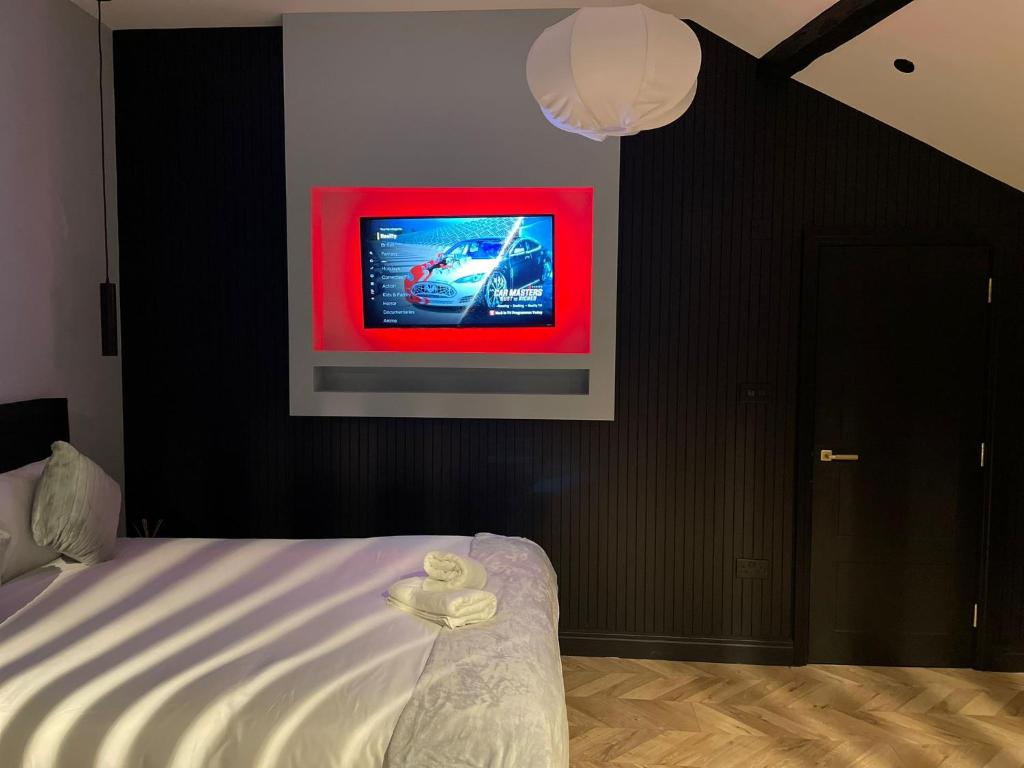 a bedroom with a bed with a tv on the wall at Luxury Home in Blackpool in Blackpool