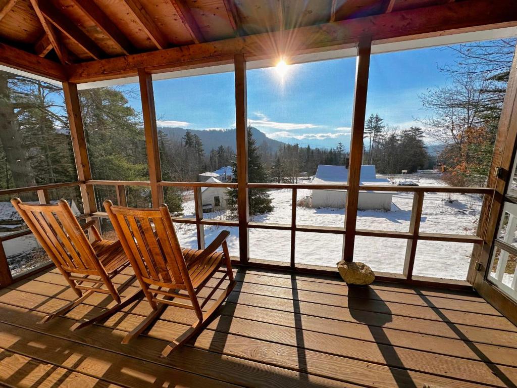 two chairs sitting on a porch with a view of the mountains at 11G Quintessential New Engalnd Cottage with Fantastic Views! in Sugar Hill