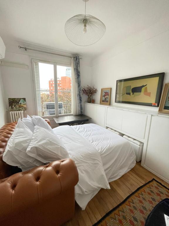 ein Schlafzimmer mit einem weißen Bett und einem Sofa in der Unterkunft AIR CONDITIONING - METRO 14 - CHARMING TRADITIONAL STYLE AND MODERN ACCESS 10 MN AWAY FROM CENTER Of PARIS in Clichy