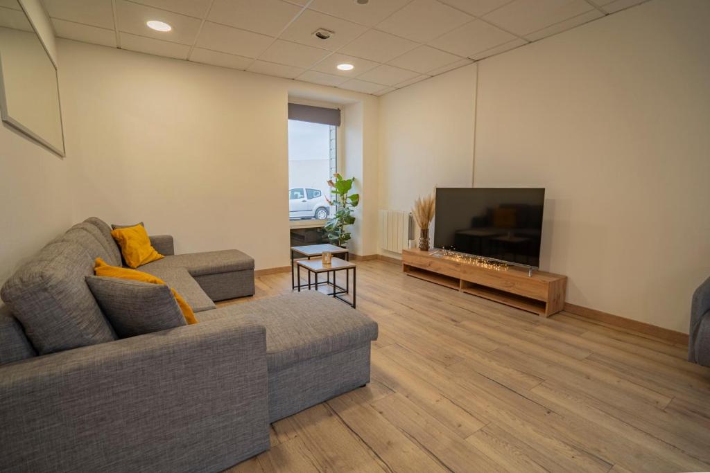 uma sala de estar com um sofá e uma televisão de ecrã plano em Maison ville Familial 50m2 + Jardin - L'atlas Zen em Challans