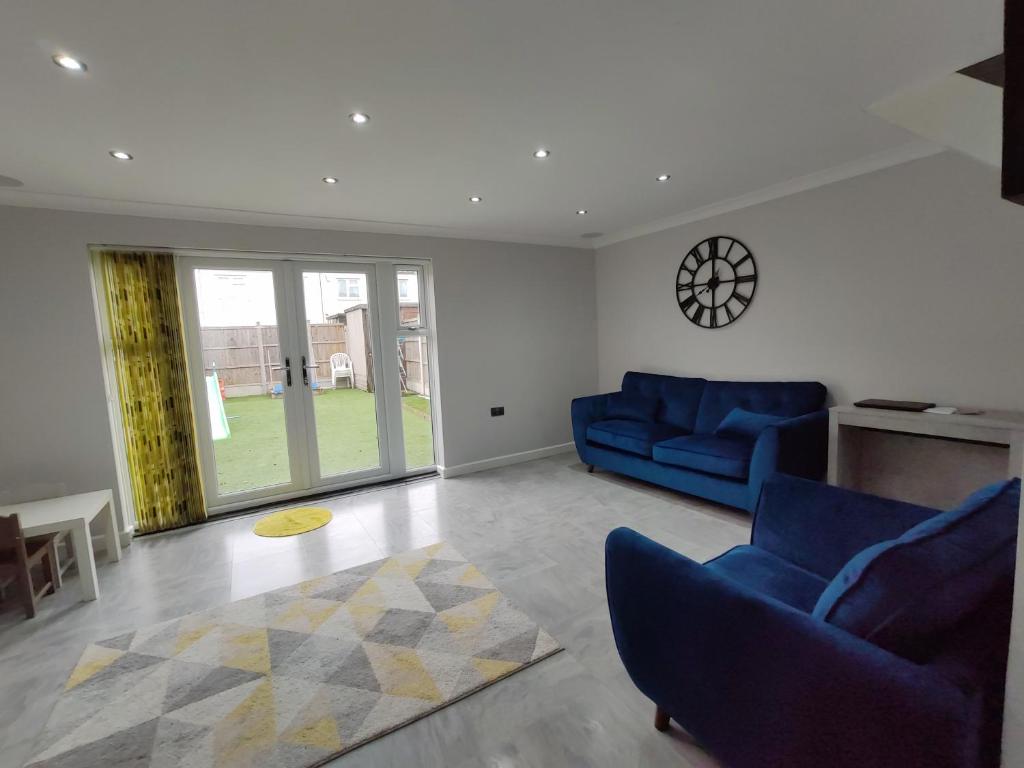 a living room with two blue chairs and a table at Elegant 3-Bedroom Home, sleeps up to 5 guest. in South Ockendon