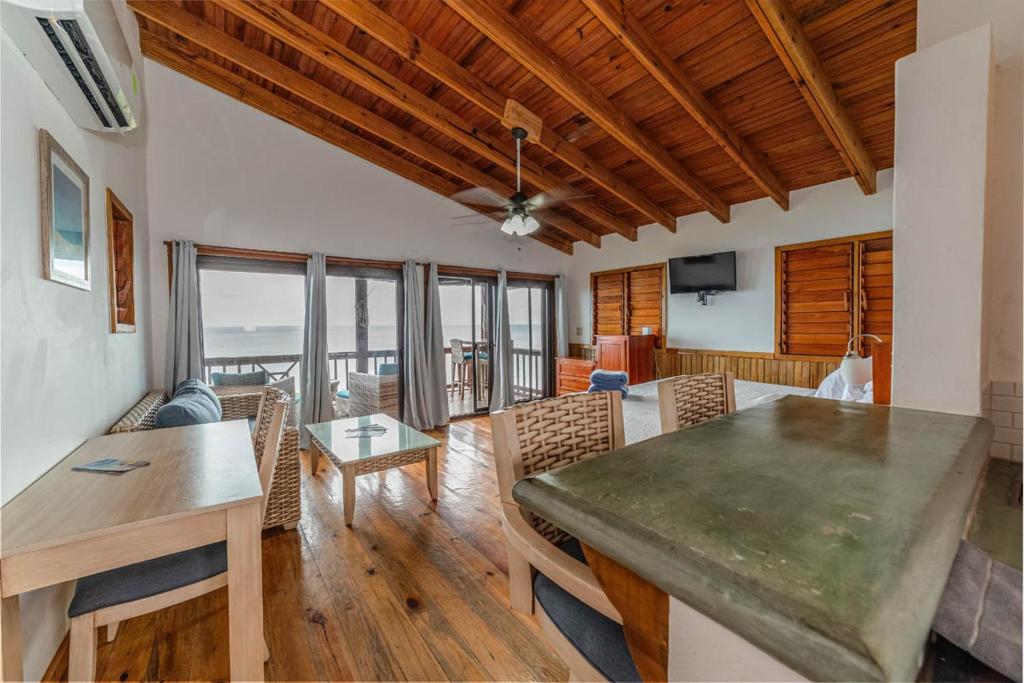 a dining room and living room with a table and chairs at Cocolobo Resort in West End