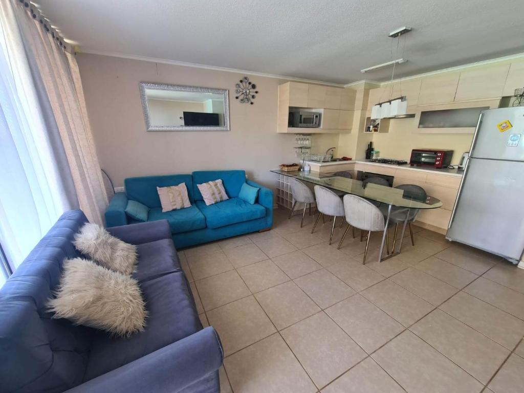 een woonkamer met een blauwe bank en een keuken bij Dpto duplex 2 dormitorios 2 baños en Laguna Vista ,Algarrobo in Algarrobo