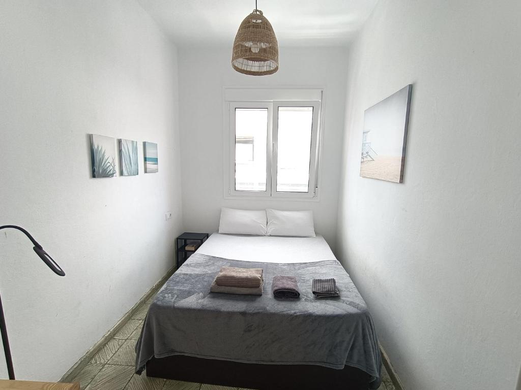 1 dormitorio con 1 cama en una habitación blanca en Club Náutico Tomas Miller, en Las Palmas de Gran Canaria