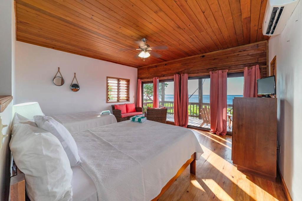 a bedroom with a bed in a room with windows at Cocolobo Resort in West End