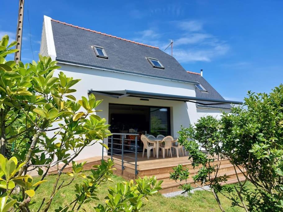 une maison dotée d'une terrasse avec deux chaises et une table dans l'établissement Le Sanderling, à Trégunc
