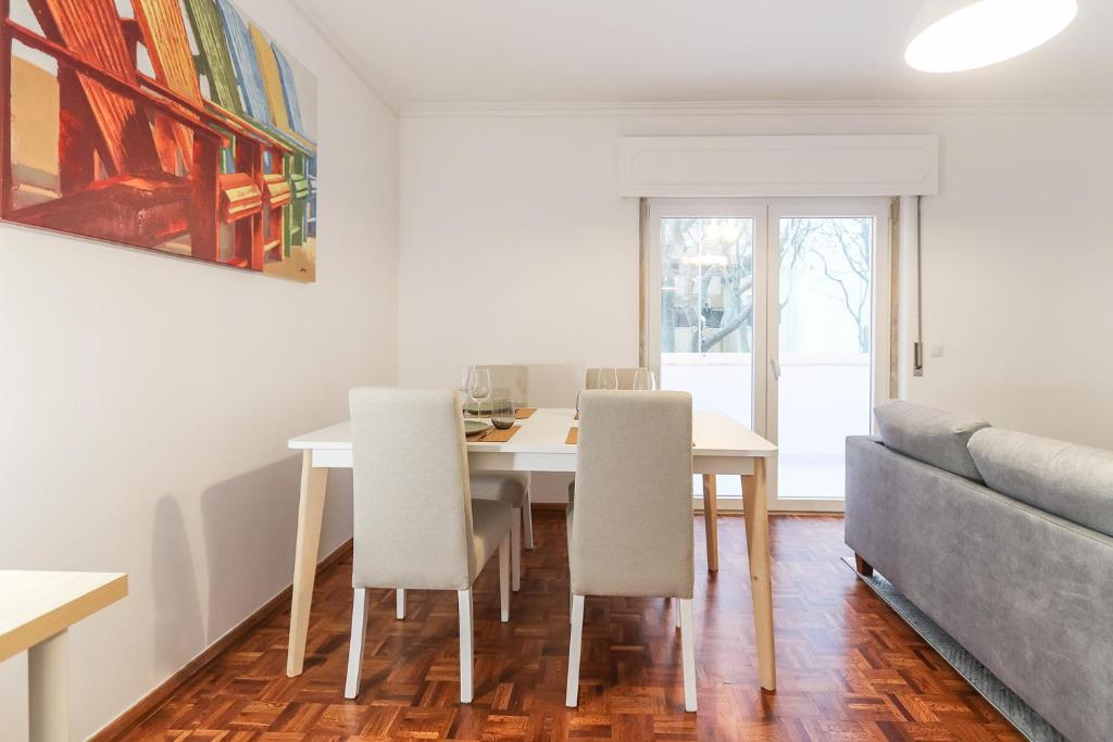 comedor con mesa, sillas y sofá en Cascais Beach Flower Apartment en Estoril
