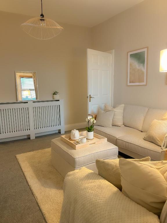 a living room with a couch and a table at Paupies Place Seaside Stay in Cullercoats