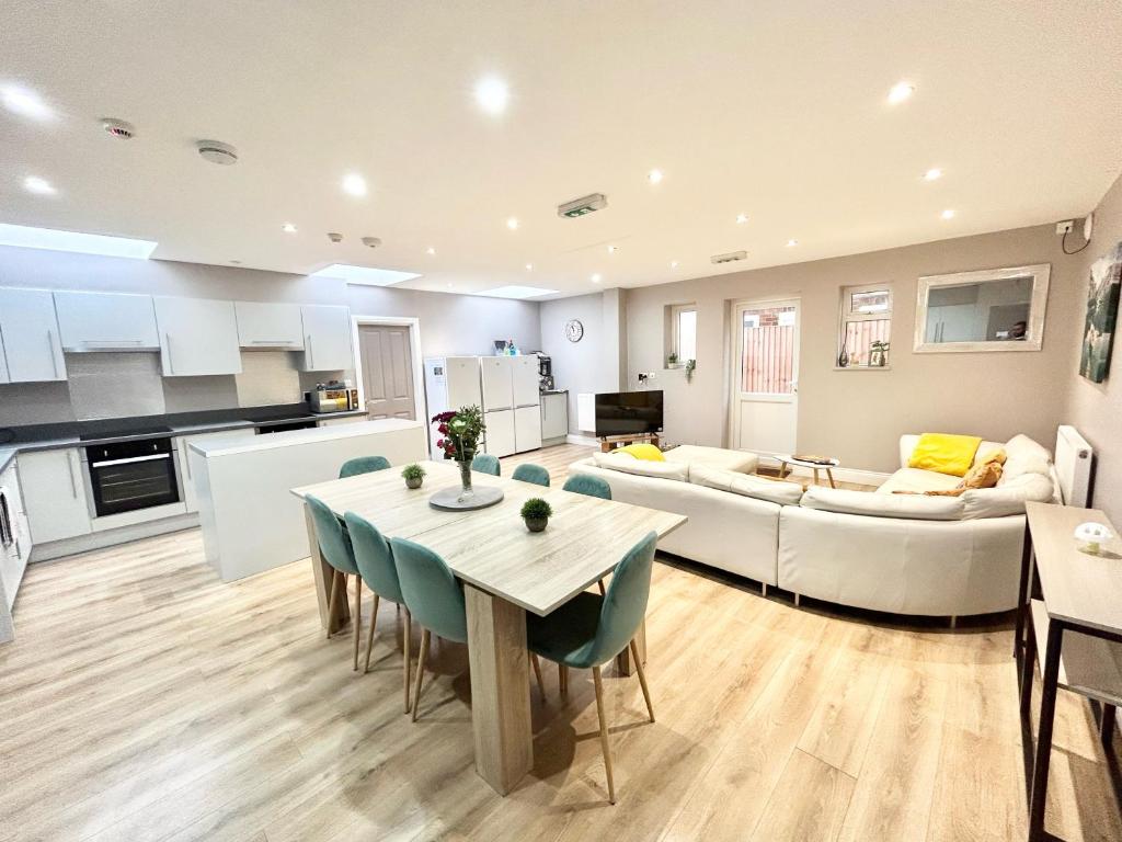 a kitchen and living room with a table and a couch at The Winstre Borehamwood in Borehamwood