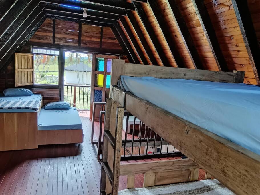 sypialnia z 2 łóżkami piętrowymi w drewnianym domku w obiekcie Chalet MOKA la Riviera w mieście Calima