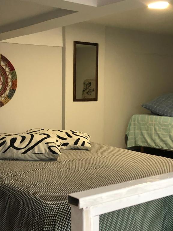 1 dormitorio con 1 cama con edredón blanco y negro en Residencial Estrela Dalva- 450 metros do mar, en Florianópolis