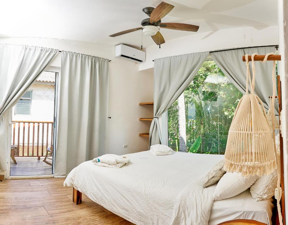 a bedroom with a swinging bed with a ceiling fan at Aaki Hotel in Las Peñitas