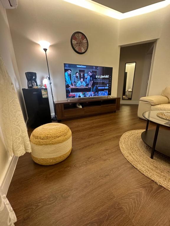 simple house في الرياض: غرفة معيشة مع تلفزيون بشاشة مسطحة وطاولة