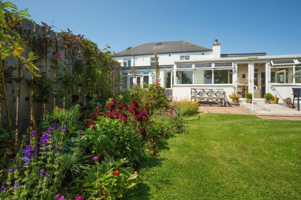 una casa con un jardín con flores en el patio en Chillington House en Kingsbridge