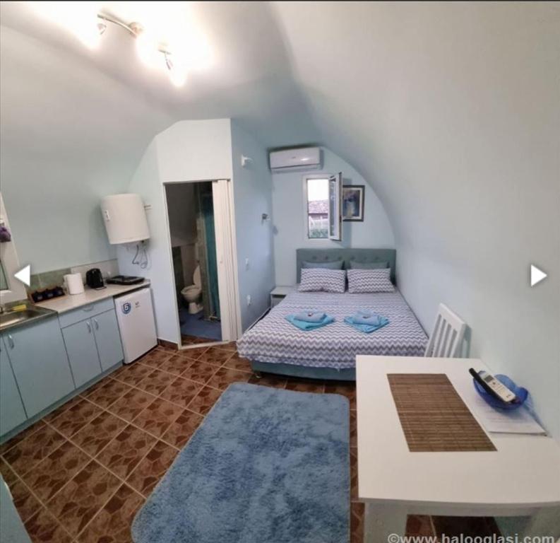 ein Schlafzimmer mit einem Bett und einem Tisch in einem Zimmer in der Unterkunft Yellow story in Vrdnik