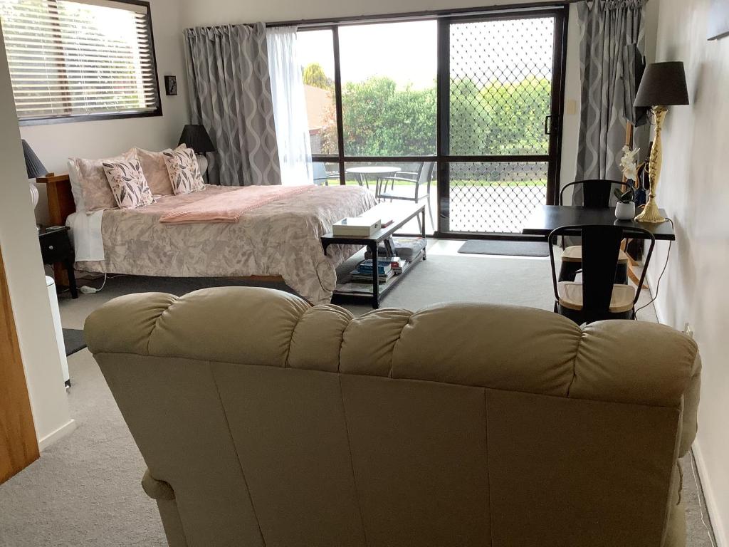 a living room with a couch and a bed at Botanical Haven BnB in Tauranga