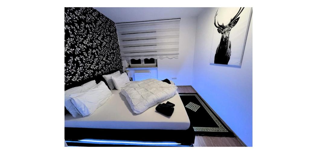 Schlafzimmer mit einem Bett mit weißer Bettwäsche und Kissen in der Unterkunft apartment ALUB in Bischofshofen