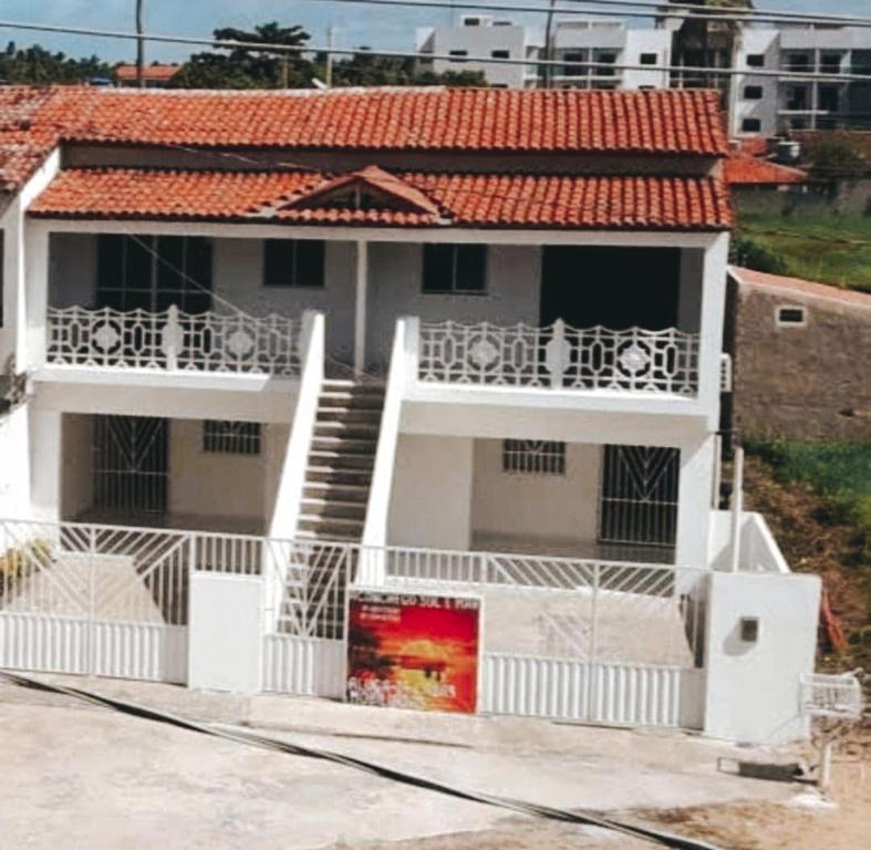 Casa blanca con escalera y balcón en Pousada Aconchego Sol e Mar, en Maragogi
