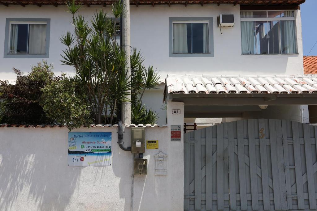 a parking meter in front of a house with a fence at Suítes Praia dos Anjos - Arraial do Cabo in Arraial do Cabo