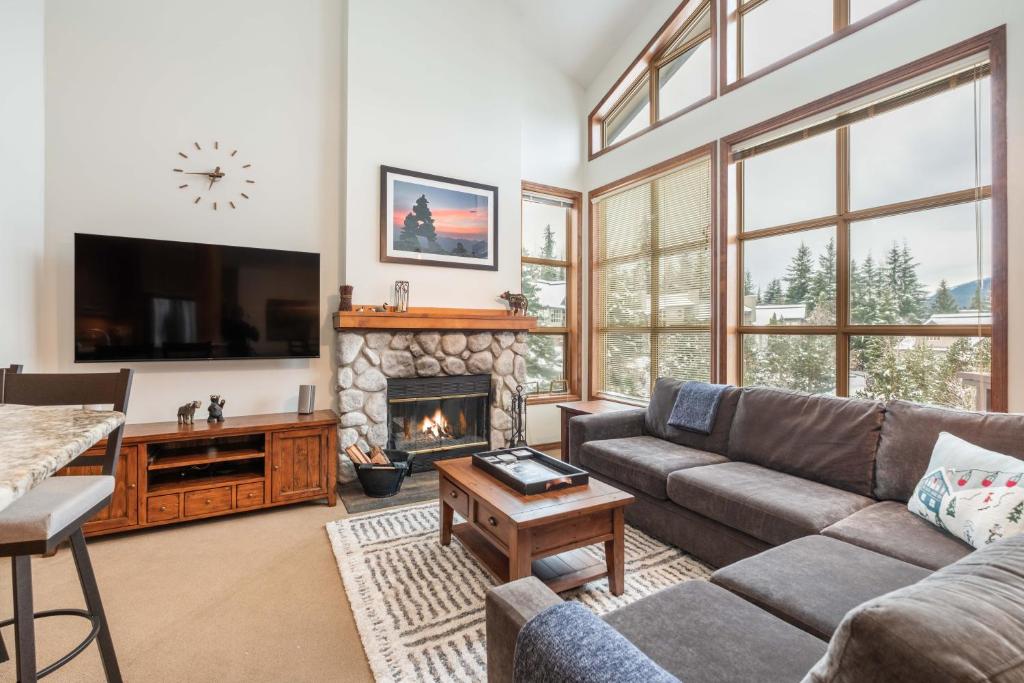 a living room with a couch and a fireplace at Blackcomb Greens by Outpost Whistler in Whistler