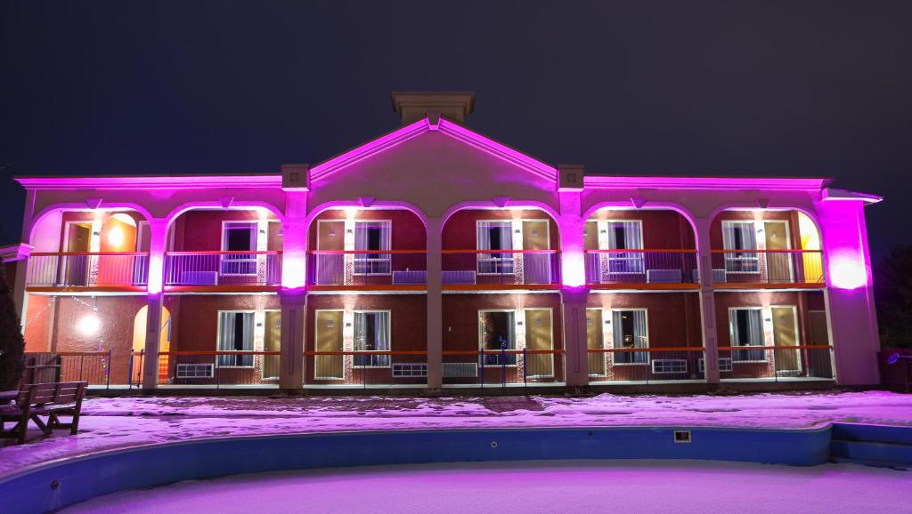 ein großes Gebäude mit rosa Lichtern drauf in der Unterkunft Motel Classique in Joliette
