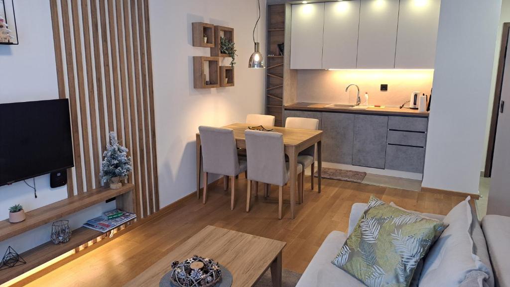 uma sala de estar e cozinha com uma mesa e um sofá em Apartman K&N - Jahorinska Vila em Jahorina