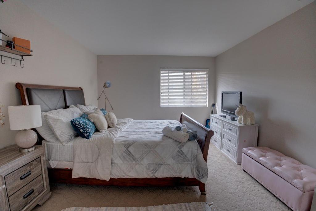 a bedroom with a bed and a television in it at 2 story Casual Cute Condo 6 miles from Disneyland & 8 miles Knotts 2bd 2bth Sleeps 8 plus in Cypress