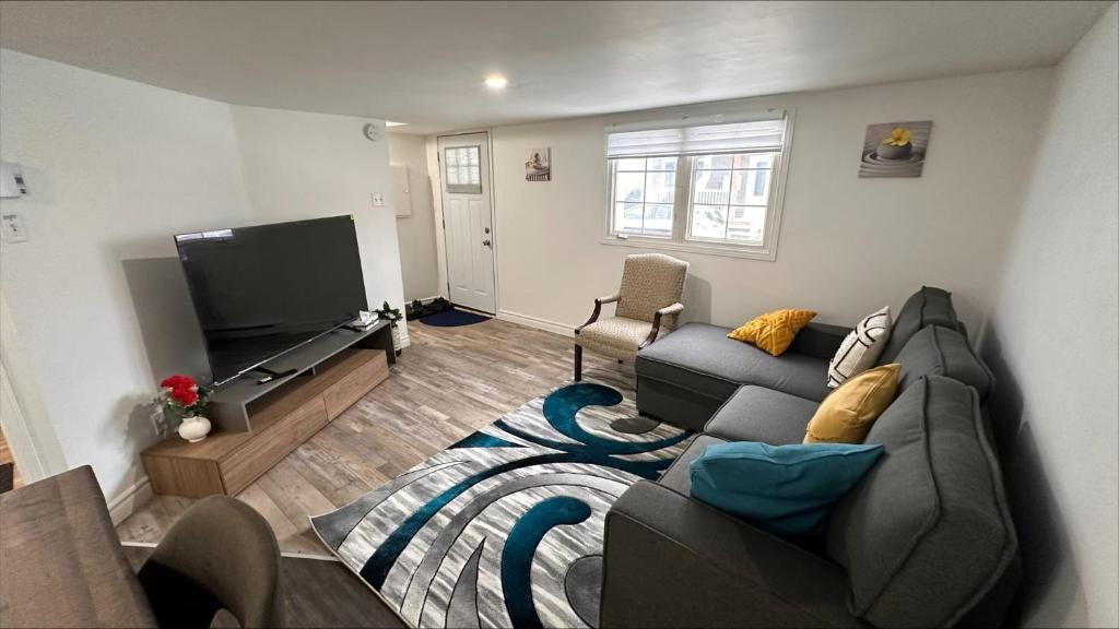 a living room with a couch and a flat screen tv at Le Cent Onze in Gatineau