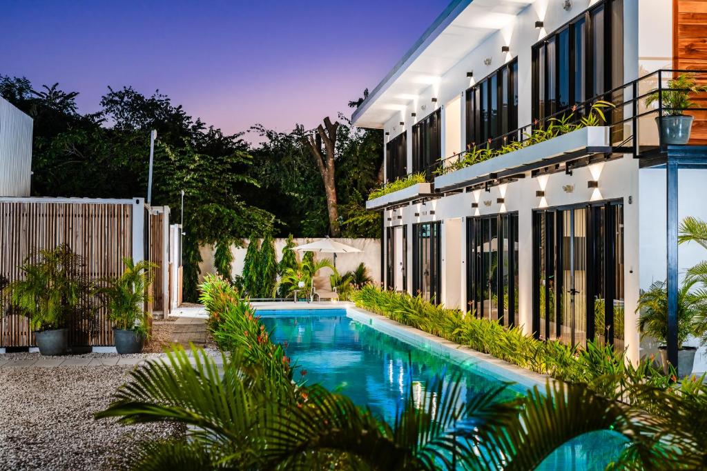 a swimming pool in front of a building at House of Nomad - Adults only in Tamarindo