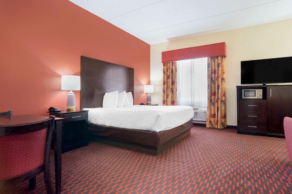 a large hotel room with a bed and a television at Best Western Plus Flowood Inn & Suites in Flowood