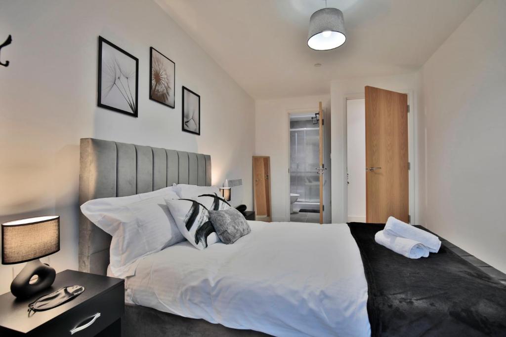una camera con un grande letto bianco e una lampada di KA Propertiess - 2Bed & 2Baths Ensuite, Parking, Balcony, Wi-Fi, Netflix, Media City a Manchester