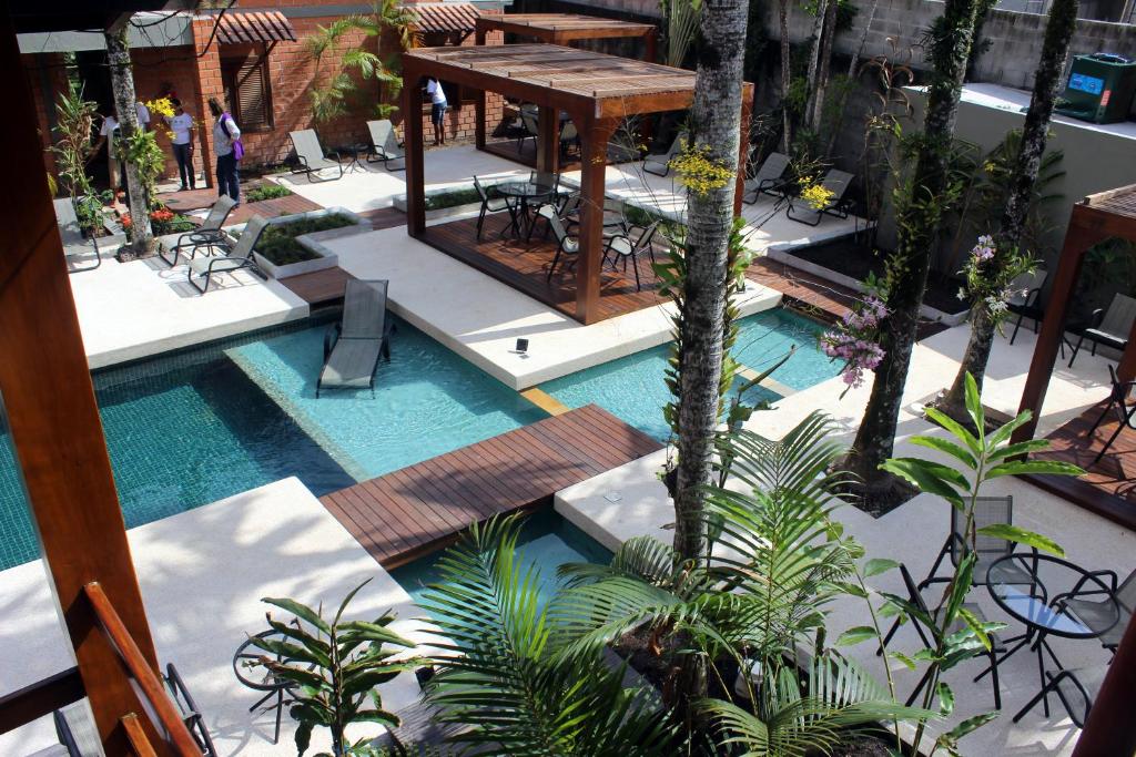 an overhead view of a pool with a table and chairs at Pousada do Rosa Camburi in Camburi