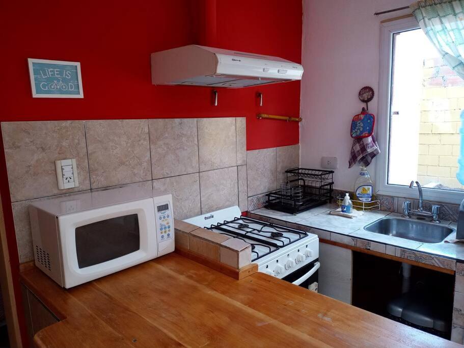 a kitchen with a microwave oven and a stove at Casa Grilli cerca de la terminal in Río Gallegos
