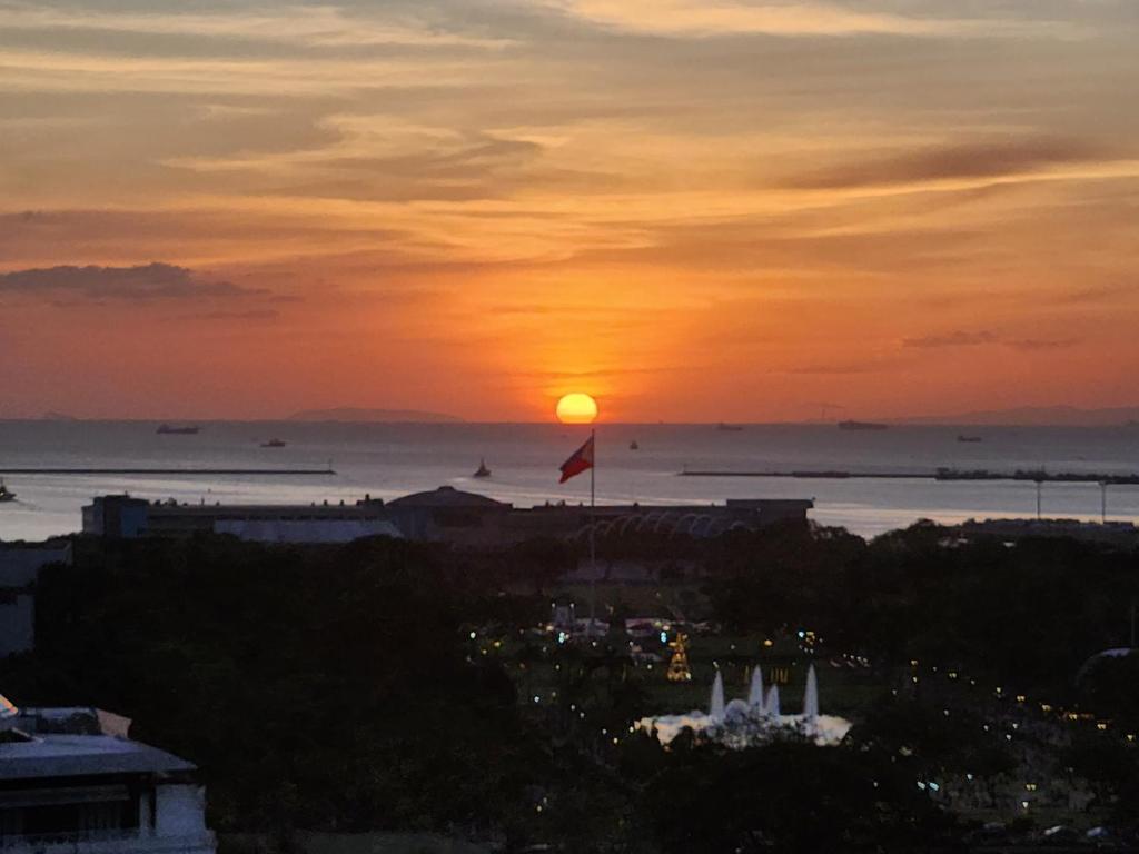 a sunset over the ocean with the sun in the sky at Manila Condo in front of Rizal Park Taft Ave LRT UN Station Unli WiFi Netflix Disney Youtube by 24K Residences in Manila