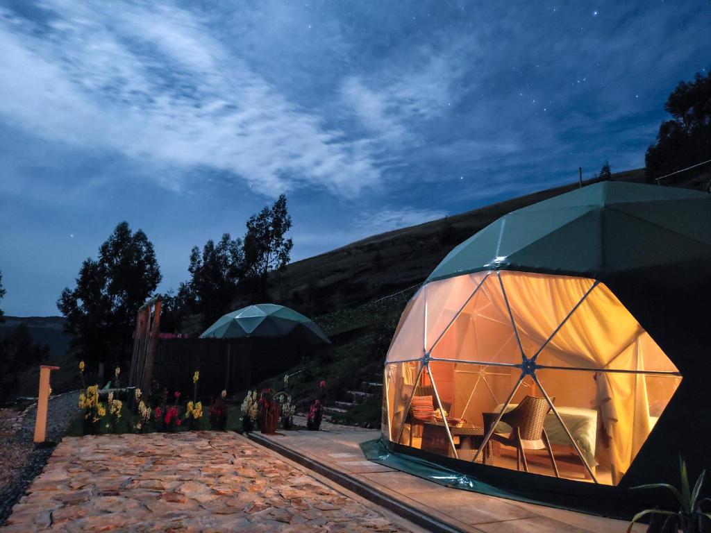 uma grande tenda cúpula sentada no topo de um campo em Pacucha Glamping em Andahuaylas