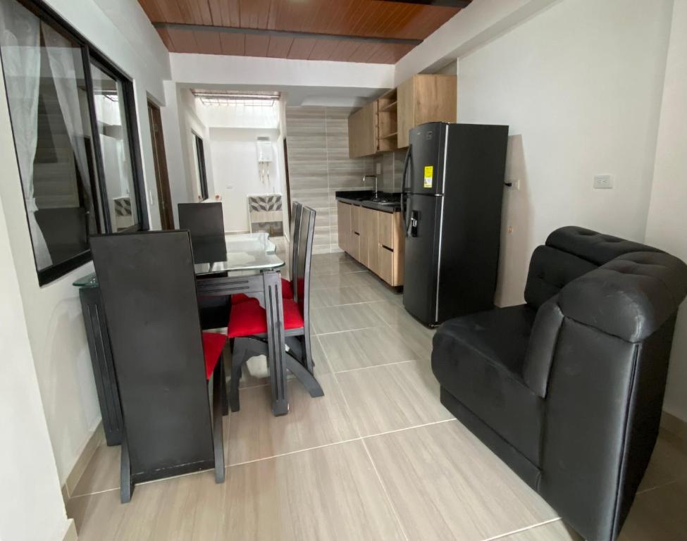 a kitchen with a table and a black refrigerator at Apartamento Confort Quindío in Calarcá