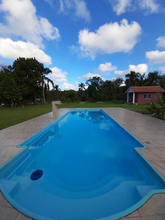 a large blue swimming pool on a patio at Mini Casa Chácara Zulin's - AMOR E ACONCHEGO in Pontal do Paraná