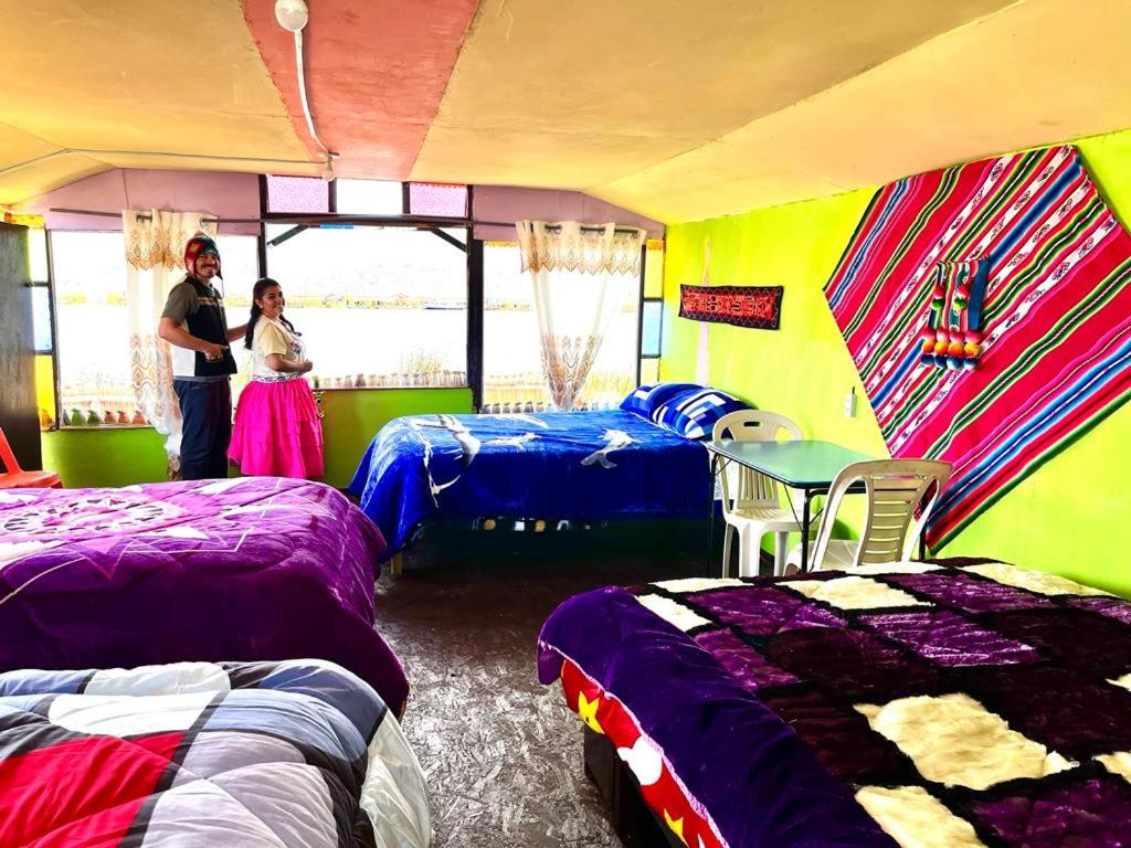 duas pessoas num quarto com camas em Urosfood & Titiqaqa Lodge em Uros