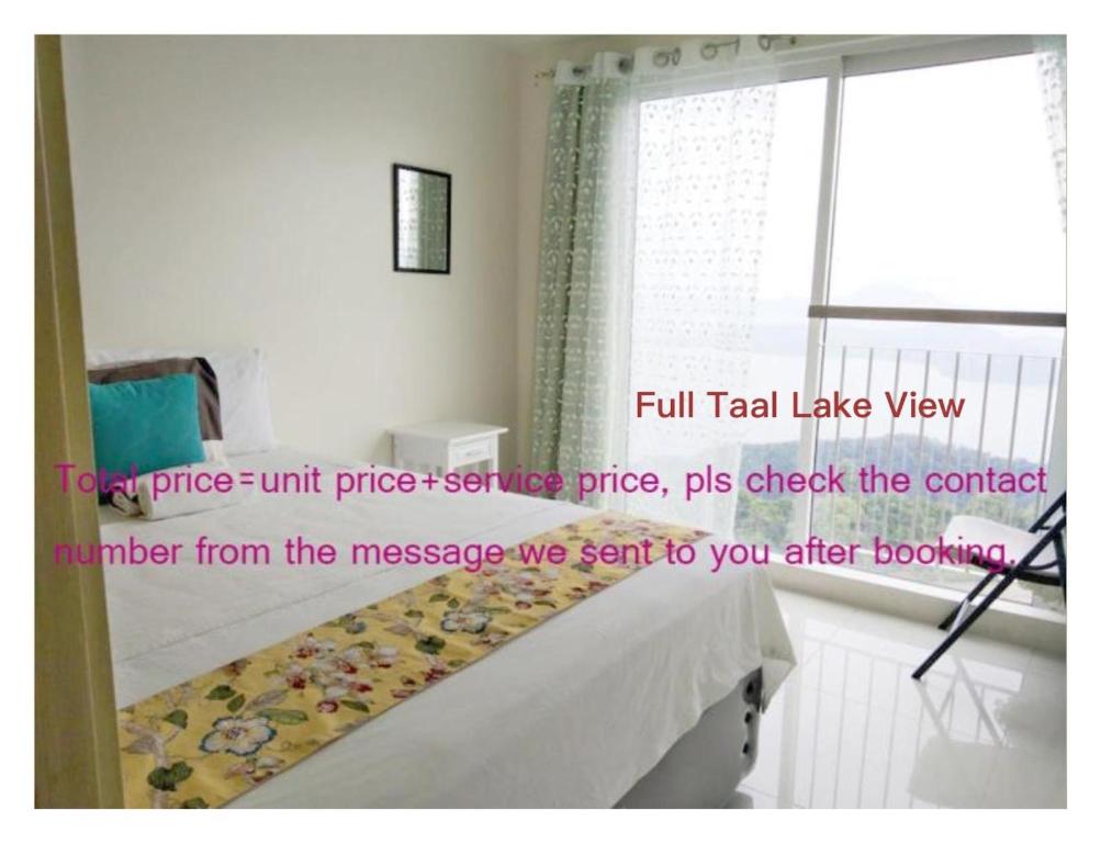 a room with a bed and a window and avertisement at SMDC Franchesca's Taal Lake View Condo No Balcony - Studio & Partial Lake View Condo No Balcony - Standard Quadrouple Room Netflix in Tagaytay