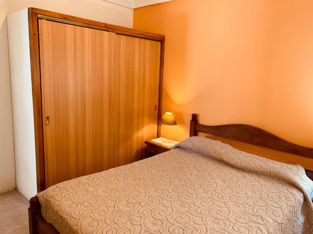 une chambre avec un lit et une porte en bois dans l'établissement SanVitto, à Las Grutas