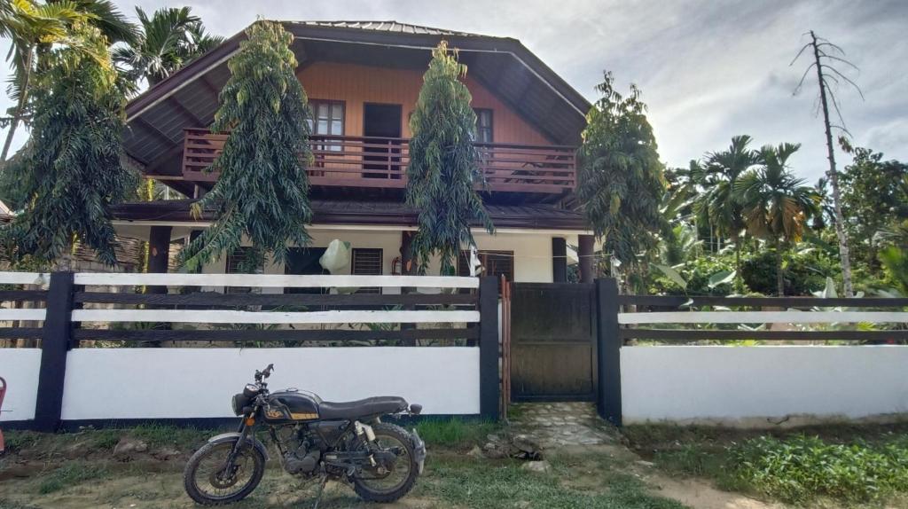 a motorcycle parked in front of a house at KALAYAAN INN in Port Barton