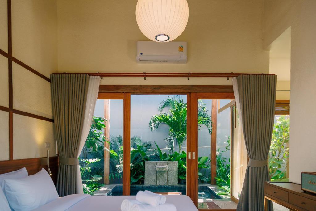 a bedroom with a bed and a large window at Mamori House at Kohlarn in Ko Larn