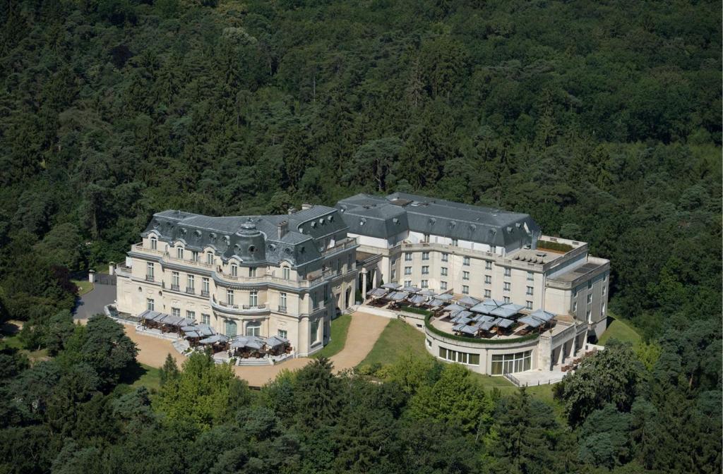 - une vue aérienne sur une grande maison dans la forêt dans l'établissement InterContinental Hotels Chantilly Chateau Mont Royal, an IHG Hotel, à La Chapelle-en-Serval