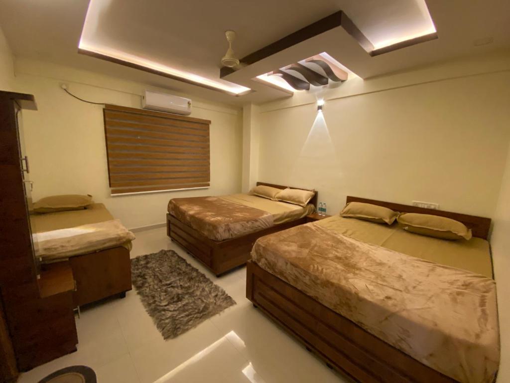 a room with two beds and a window in it at AL-MANAL 305 Premium Room 5 beds in Bhatkal